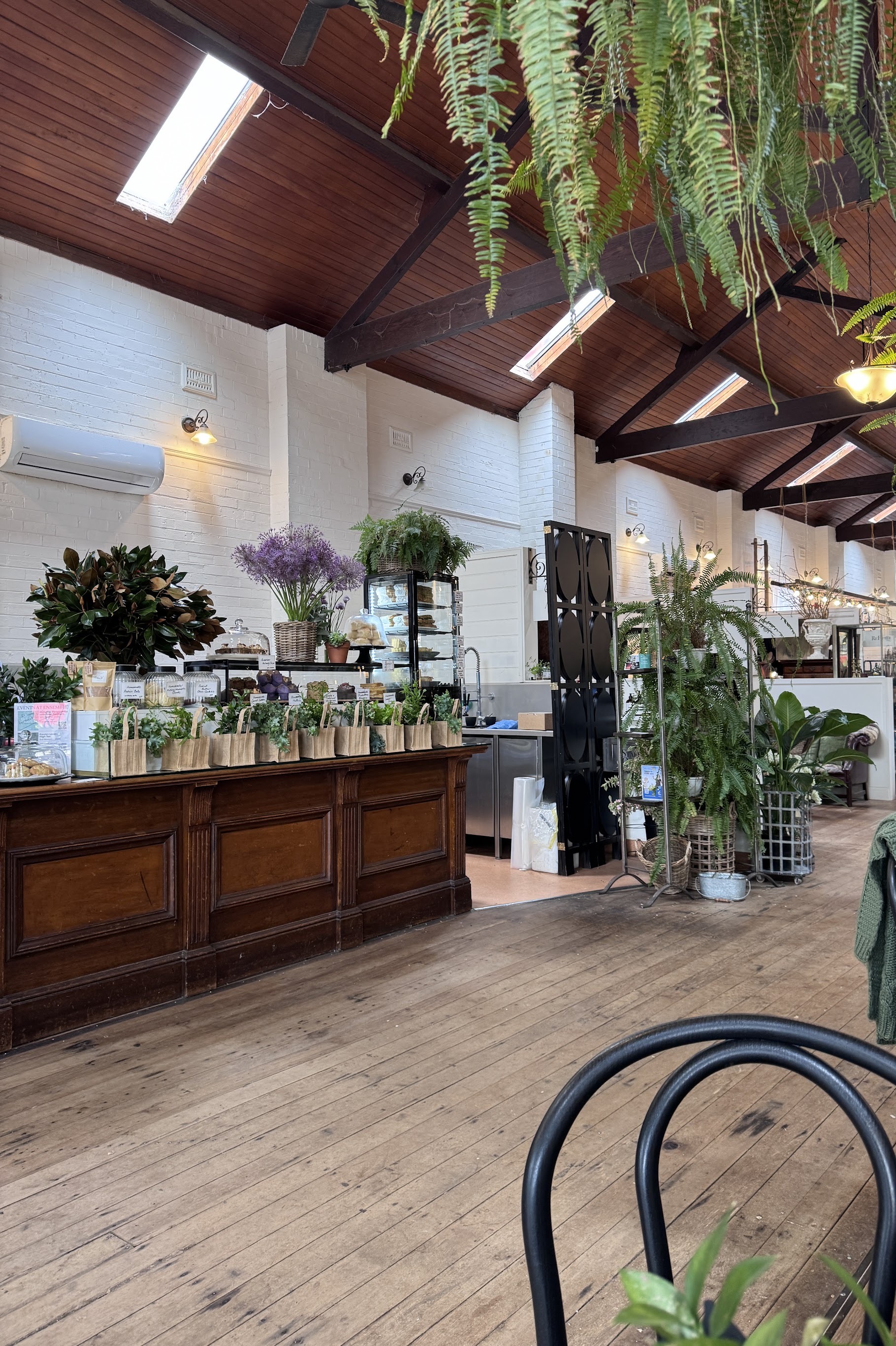The main room looking down the timber aisle, with a high vaulted ceiling, dark beams and the original counter